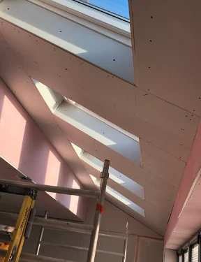 Plasterboard dry lining fitted to a loft conversion ceiling with skylights